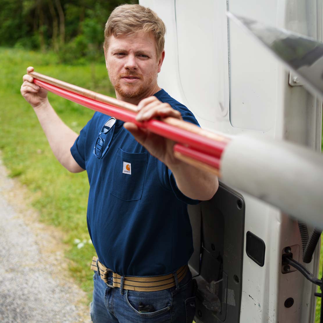 Plumber taking piping out of a van