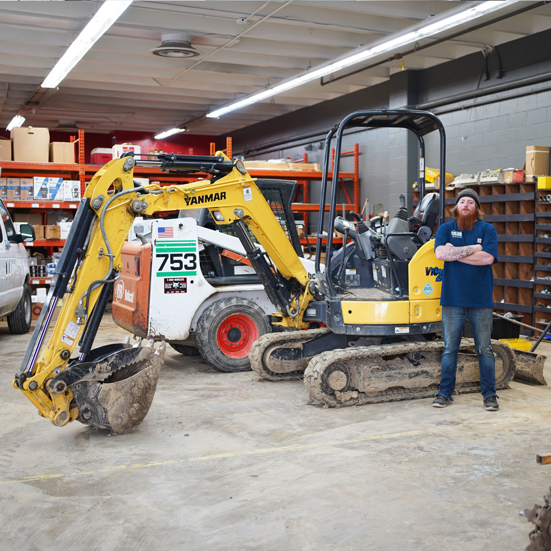 Plumber next to an Excavator